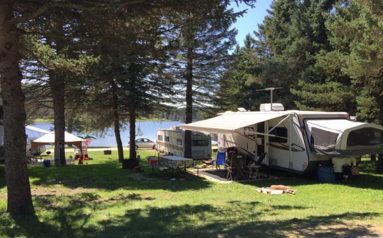A group of RVs parked in a campground next to Rainbow Lake in western New York.