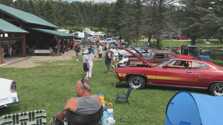 A group of people gathered at an RV resort for a car show.