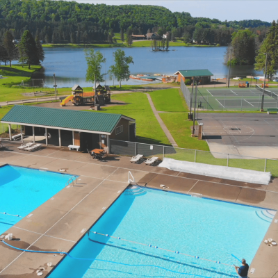 An aerial view of a wny campground with swimming pool and tennis courts.