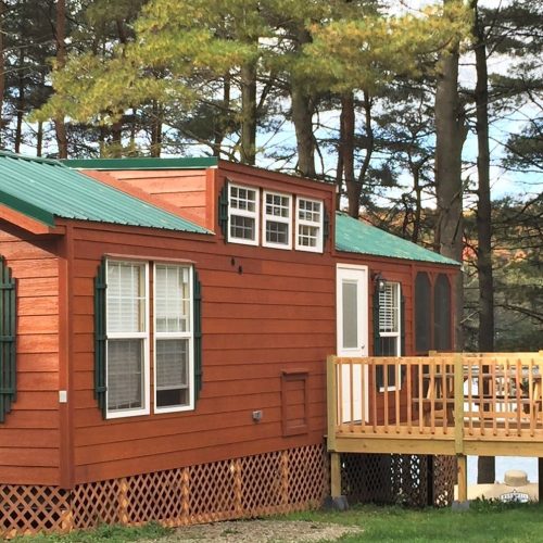 A small cabin in Western New York with a green roof nestled near Rainbow Lake.