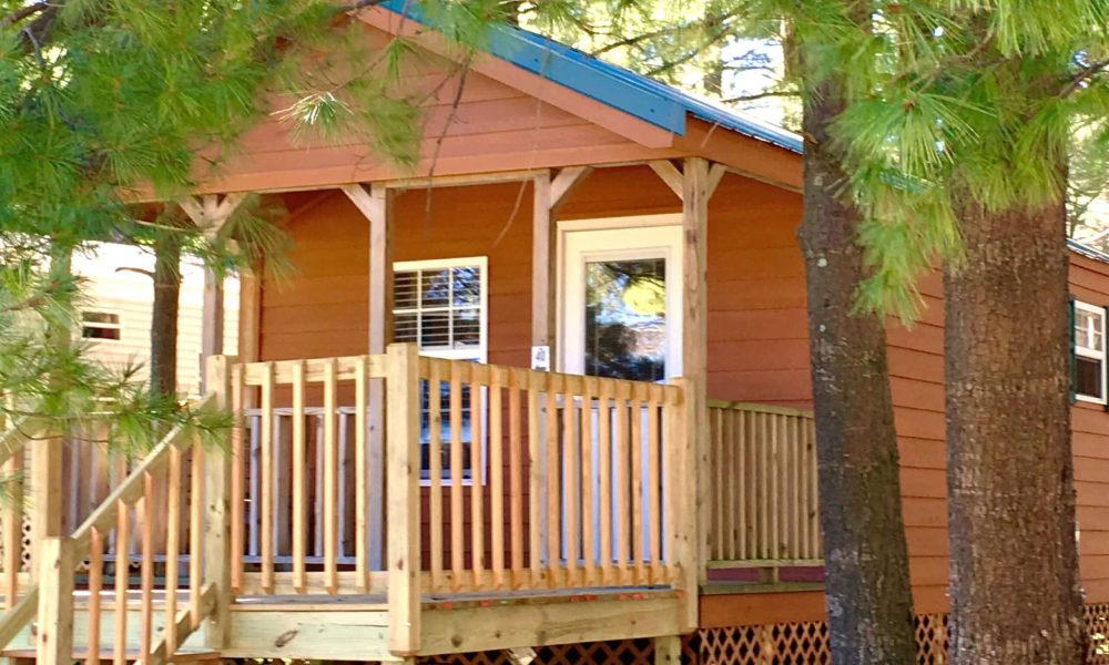 A cozy cabin nestled in the serene woods of Western New York, complete with a charming deck.