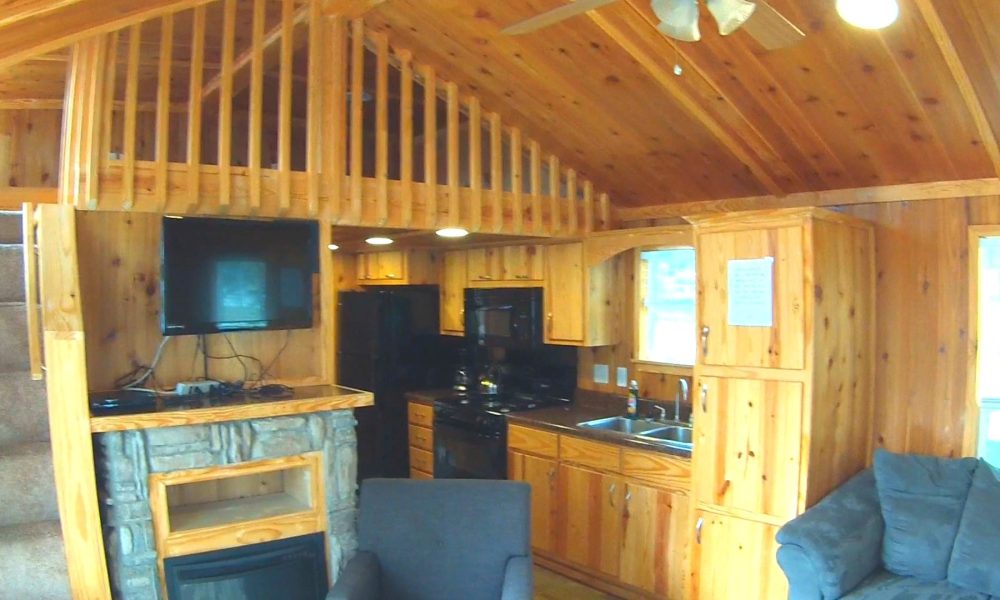 A cozy cabin equipped with a kitchen and living room, perfect for a family camping getaway at a campground.
