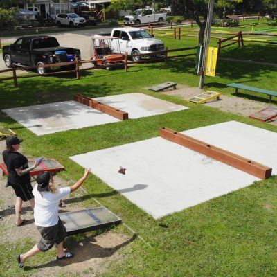 A group of people playing a game of shuffleboard at a cabin in western New York.