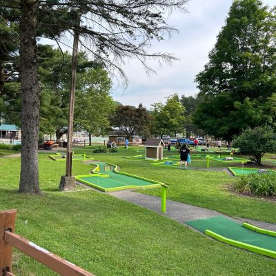 A mini golf course nestled in a park surrounded by trees, perfect for a fun and relaxing day of outdoor activities.
