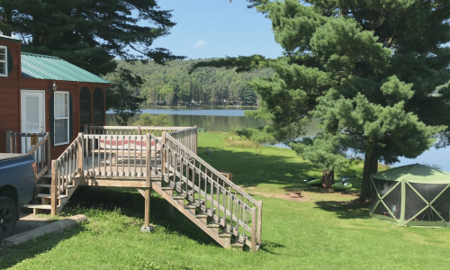 A cozy tiny house on Rainbow Lake with a deck in an rv resort.