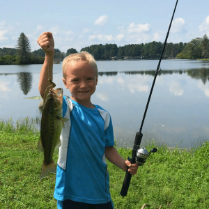A young boy holding up a fish at Rainbow Lake.