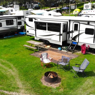A group of RVs parked in a grassy area at a campground in Western New York for camping.