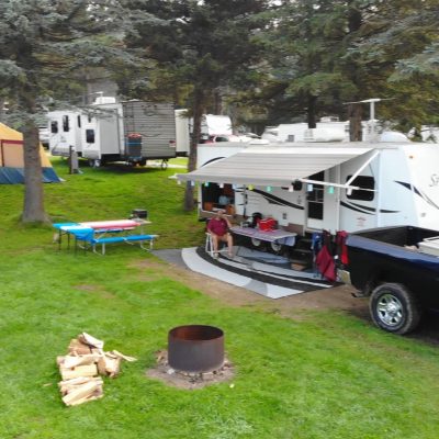 A group of rv's parked in a grassy rv campground in western New York.