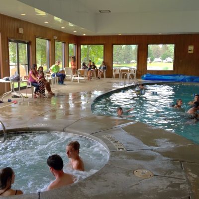 A group of people enjoying the hot tub in a large indoor pool at Rainbow Lake campground.