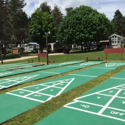 Shuffleboard courts at Rainbow Lake campground in a park.